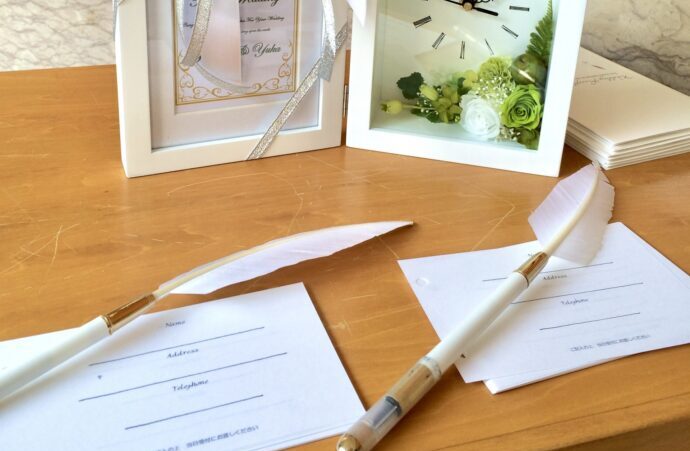 画像：カードタイプの芳名帳と羽ペンが2本、時計付きの写真立て