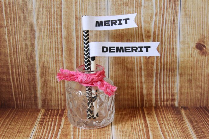画像：ガラス瓶に入ったDEMERIT MERIT と書かれたフラッグ