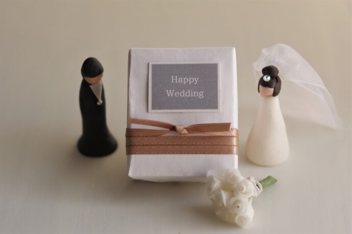 画像：happy wedding と書かれた包みを挟んで立つ花嫁と花婿のフィギュア