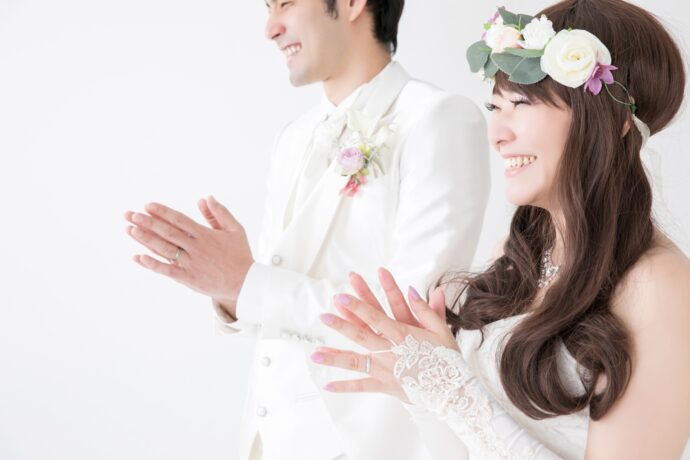 画像：手を叩いて喜ぶ花嫁と置くにいる花婿