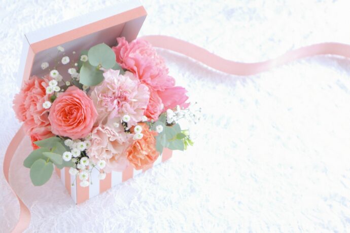 画像：白いテーブルの上に置かれたピンクの花束