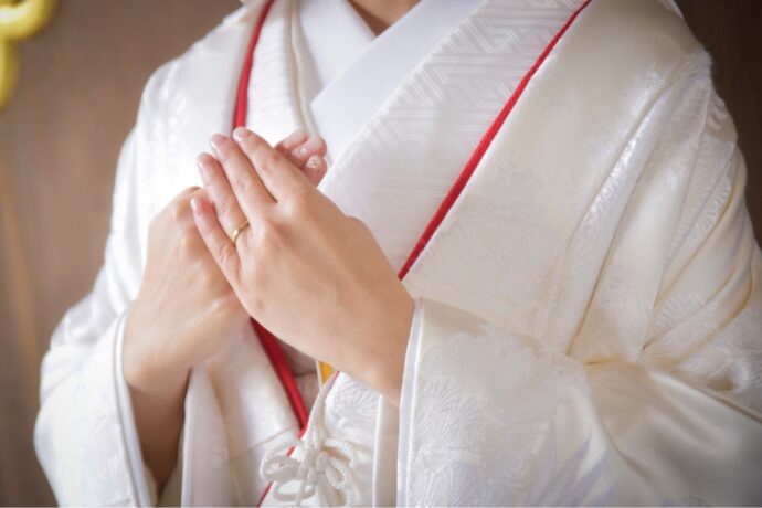 画像：白無垢を着て胸の前で手を組む新婦