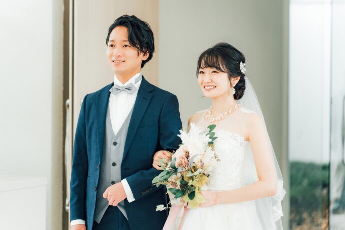 画像：腕を組み遠くを見る新郎新婦