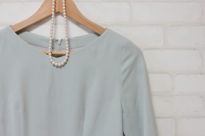 画像：ハンガーにかけられた水色の服とパールネックレス