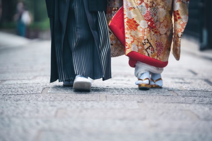 画像：紋付袴と色打掛を着て並び歩く男女の足元
