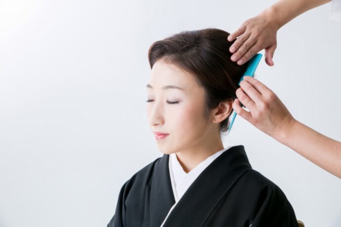 画像：ヘアセットを行う黒留袖の女性