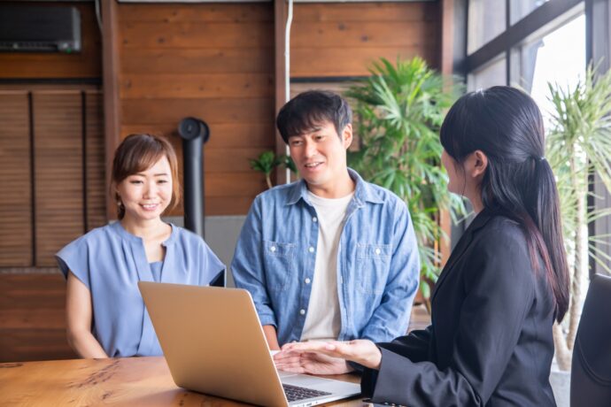 画像：若い男女と打ち合わせをするスーツの女性