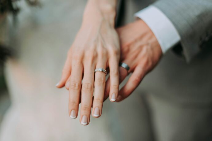 画像：結婚指輪をした手を重ねる男女
