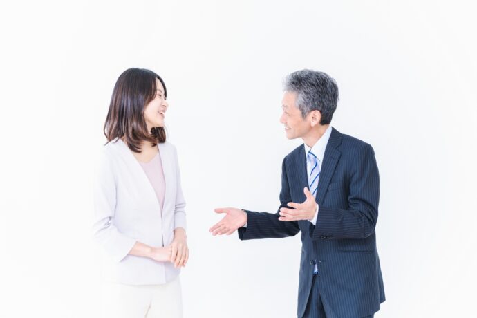 画像：話をする初老の男性と若い女性