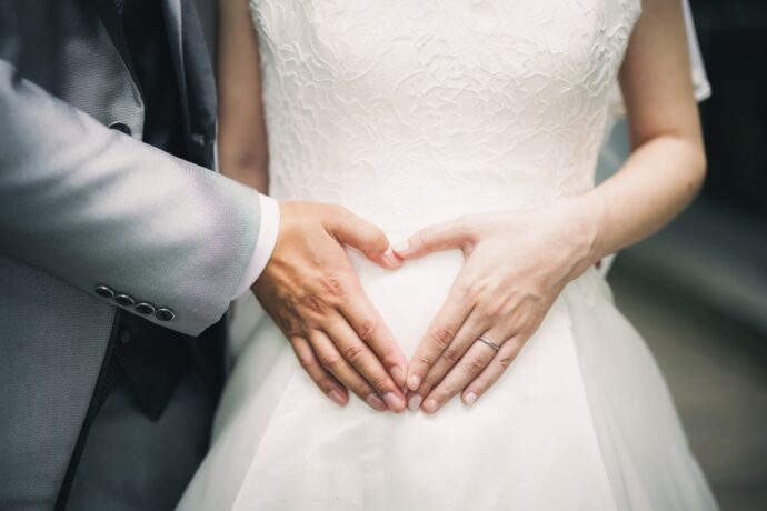 画像：お腹の前でハートを作る夫婦
