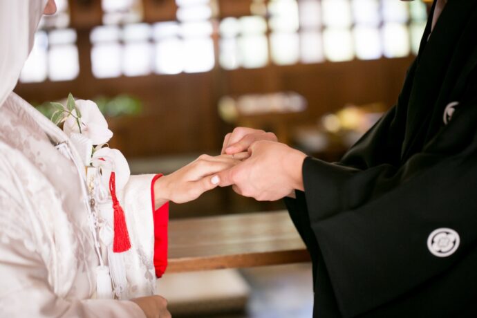 画像：指輪交換を行う和装の男女
