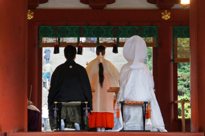 画像：神前式で席につく新郎新婦の後ろ姿