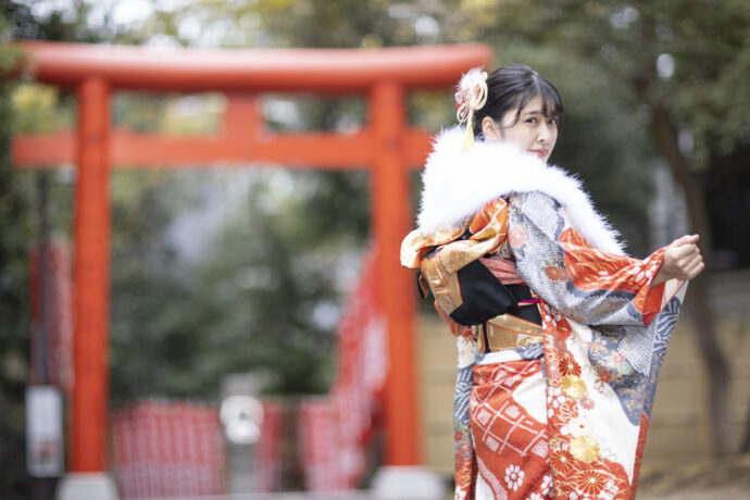 画像：鳥居のところで振り返る振袖の女性