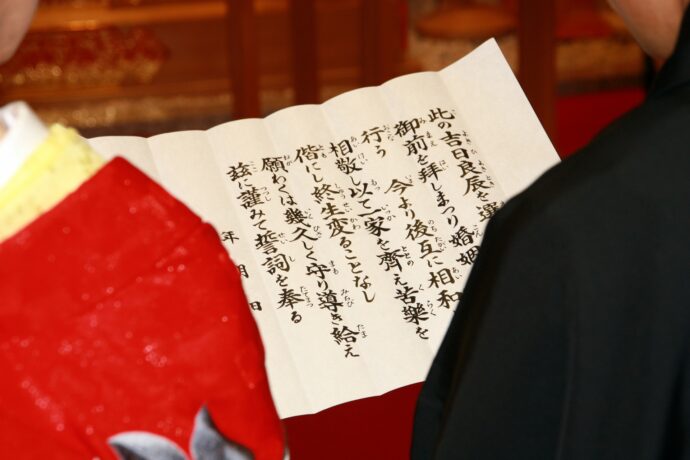 画像：誓詞を二人で持つ新郎新婦