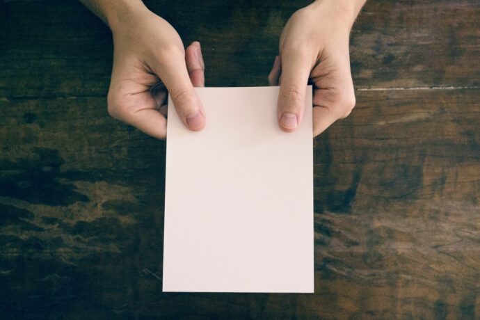 画像：白いカードを両手で差し出している