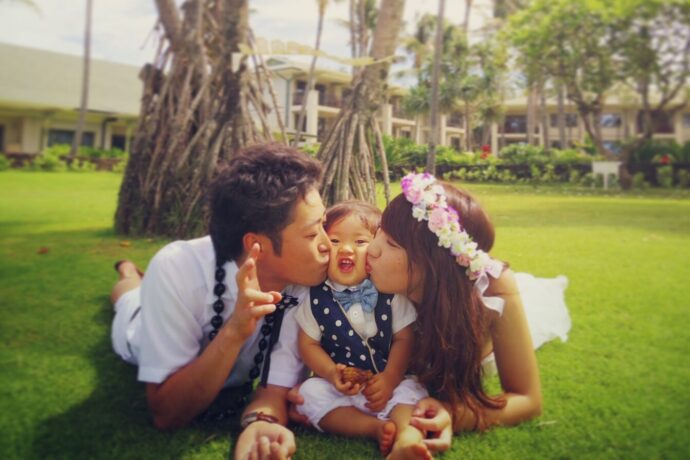 画像：両親に挟まれてキスをされる子ども