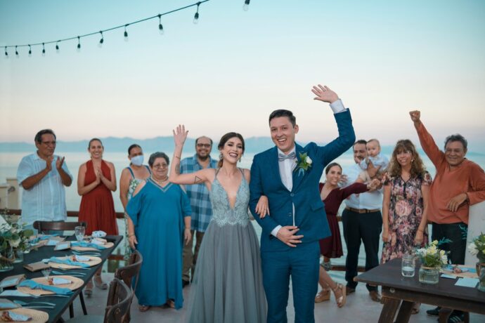 画像：家族とビーチウエディングを楽しんでいる新郎新婦