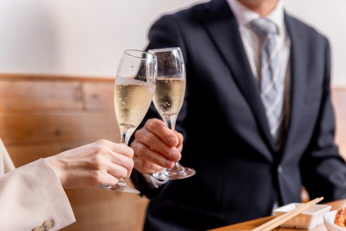 画像：グラスを合わせて乾杯する男女