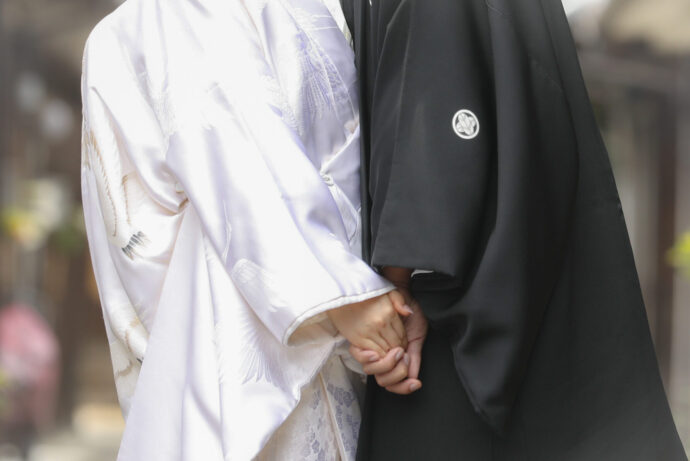 画像：手を繋ぐ和装の新郎新婦