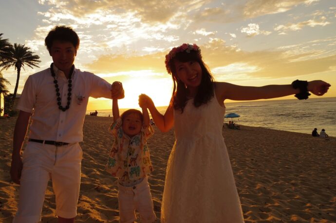 画像：夕日をバックに砂浜で撮った親子写真