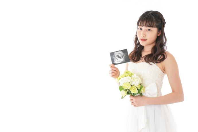 画像：エコー写真を手に持つ花嫁