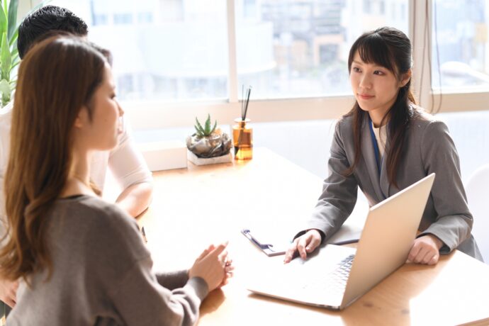 画像：スーツの女性と打ち合わせをする男女