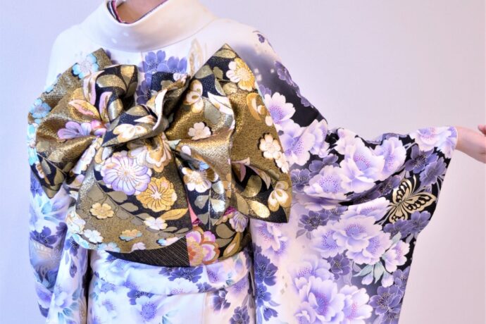 画像：白地に紫の振袖を着た女性の後ろ姿
