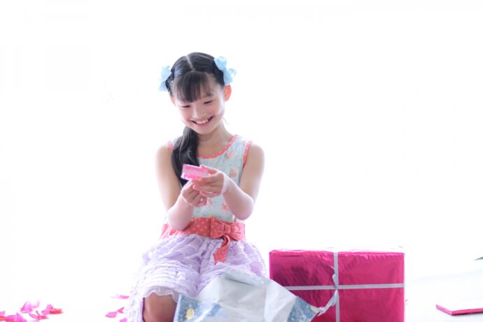 画像：プレゼントを開けて笑顔の子ども