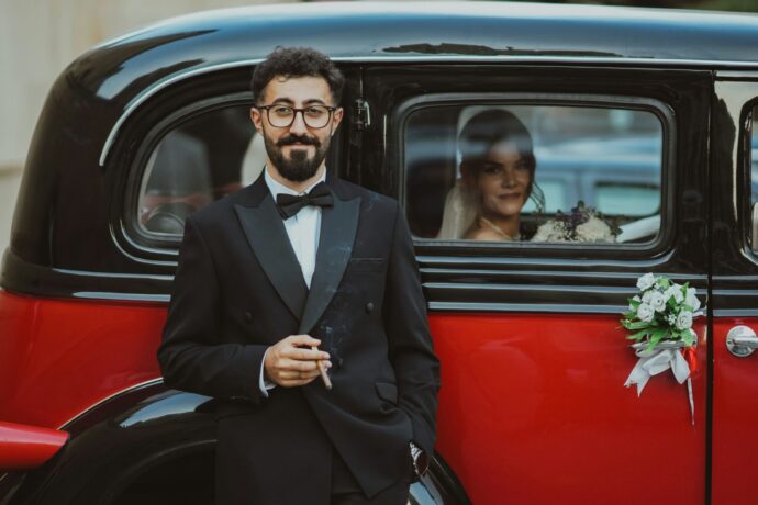 画像：ウエディングカーにもたれかかる新郎と車の中の新婦