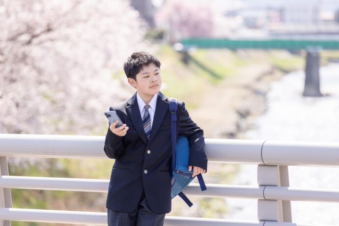 画像：欄干にもたれかかり遠くを見やる男子中学生