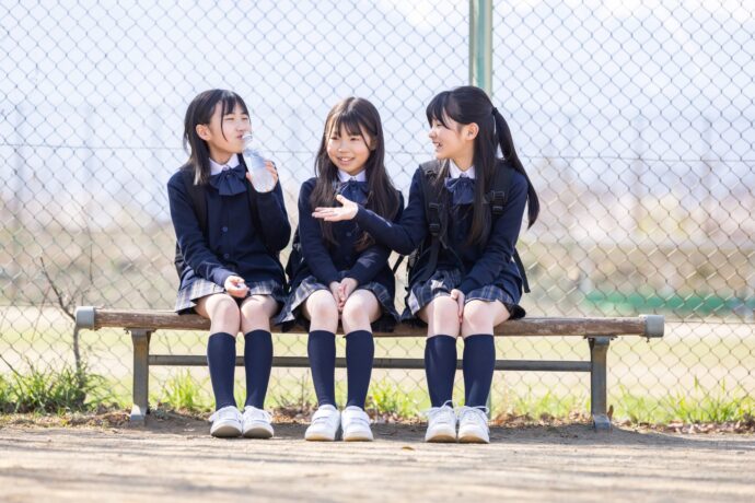 画像：ベンチに座り談笑する女子中学生