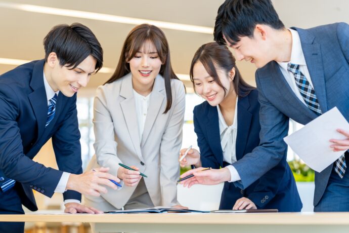 画像：スーツ姿で集まる男女数名