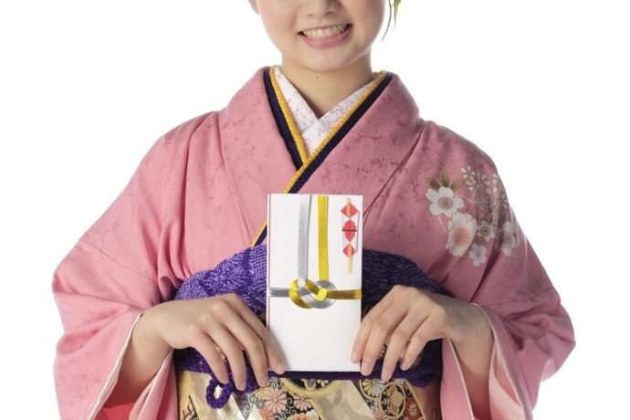 画像：振袖を着てご祝儀袋を持った女性