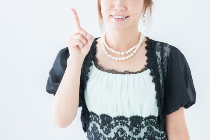 画像：ドレスを着て人差し指を立てる女性