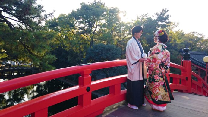 画像：太鼓橋の上で手を取り合う和装の男女