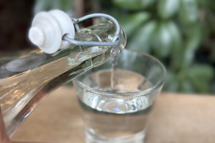 画像：ガラスのコップに水を注いでいる