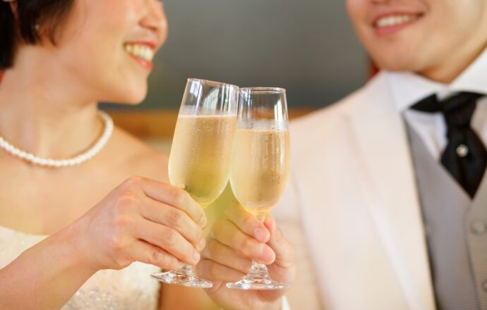 画像：シャンパングラスで乾杯する新郎新婦