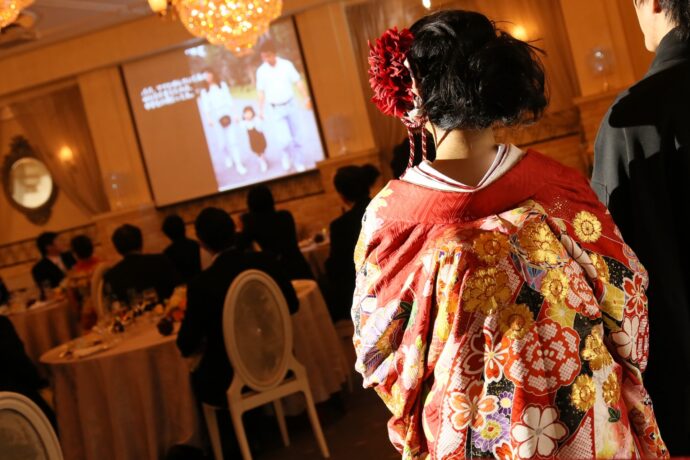 画像：ウエディングムービーを見る花嫁の後ろ姿