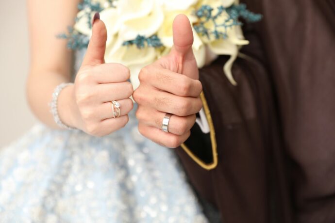 画像：親指を挙げた新郎新婦の左手