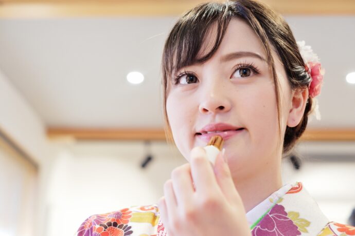 画像：リップを塗る着物の女性