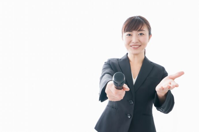 画像：こちらにマイクと手を差し出してくる女性