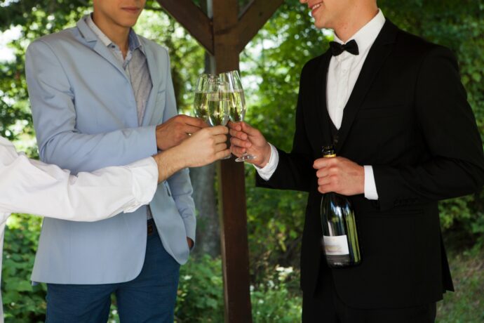 画像：乾杯するタキシードの男性