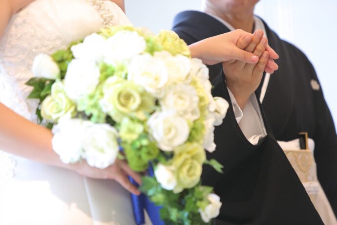 画像：黒留袖を着て花嫁の手を取る女性