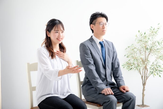画像：緊張した様子の男性と話をする女性