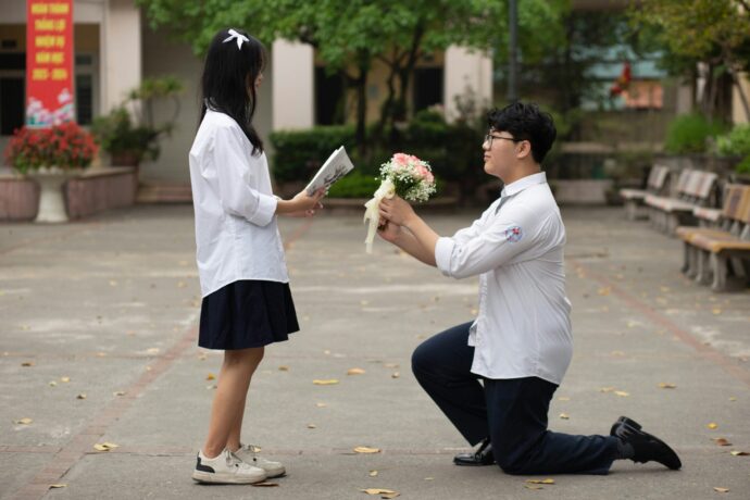 画像：片膝をついて花束でプロポーズする男性