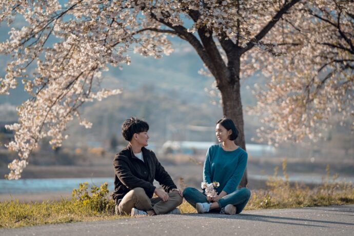 画像：桜の木の下であぐらをかく男女