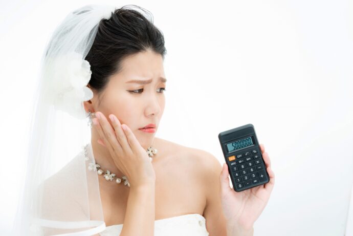 画像：電卓片手に悩む女性
