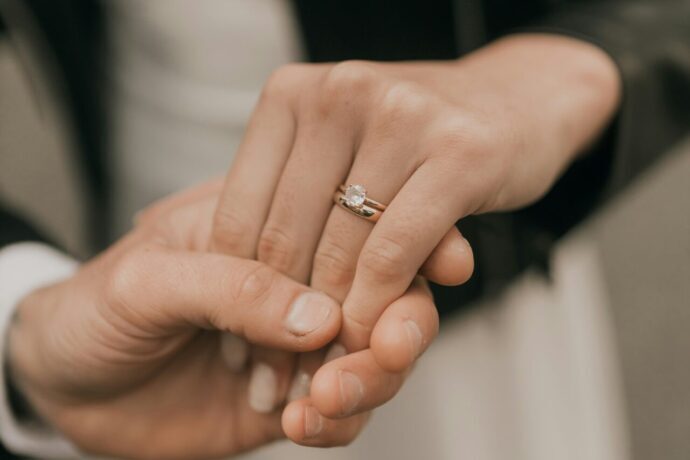 画像：婚約指輪と結婚指輪を着けた左手を取っている