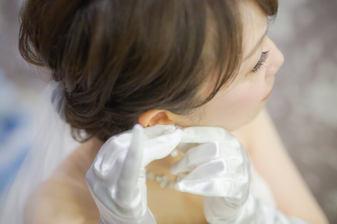 画像：イヤリングを付ける花嫁