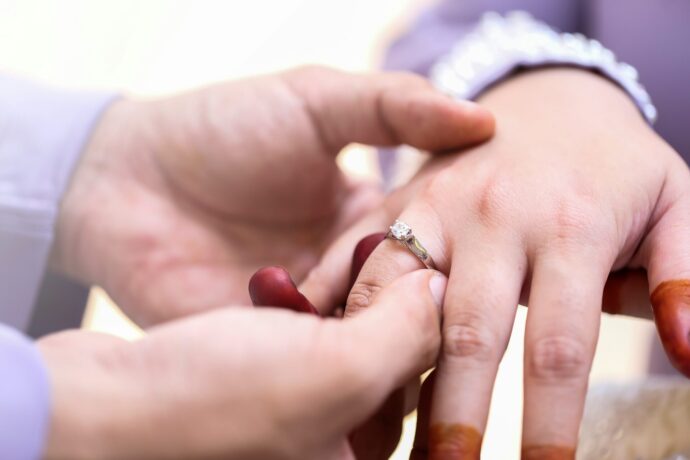 画像：婚約指輪をはめる男性の手